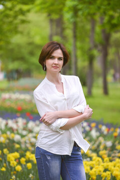 A series of photos with a beautiful young girl who walks in a spring garden with many colorful tulips