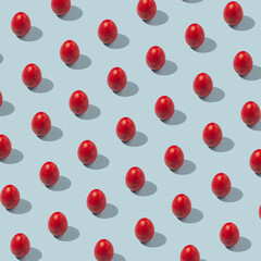 Pattern of colored eggs on a pastel blue background. The concept of minimal food