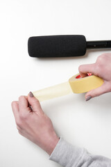 Woman using yellow duct tape on microphone to make ASMR sounds