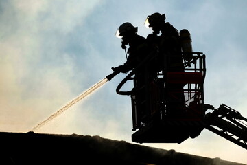 Feuerwehrleute beim Löschen eines Großbrandes in eine Halle