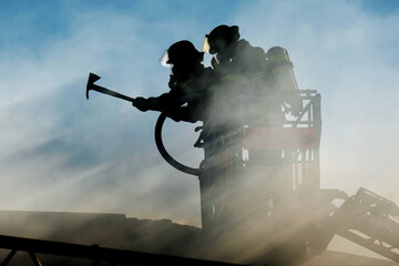 Feuerwehr Löschtrupp im Korb der Drehleiter bei Löscharbeiten