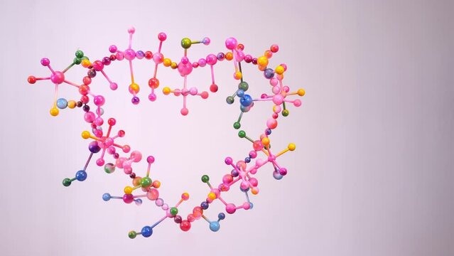 Colorful spheres balls like atoms..construction of molecular in heart shape decorate with pink tone color is mean atom of love..colorful sphere balls with a pink heart on a white background.
