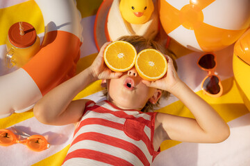 Happy child lying on beach towel