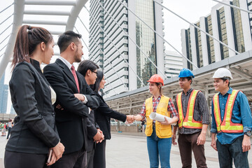 Collaboration of multiethnic group of engineers and businessperson handshake with contract agreement of big project