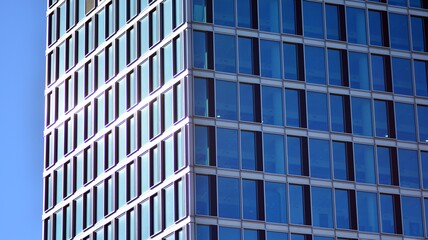 Obraz premium Urban abstract - windowed wall of office building. Detail shot of modern business building in city. Looking up at the glass facade of a skyscraper.