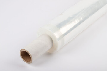 Roll of plastic stretch film with clear wrap. It stands in an isolated environment. It is used in the packaging of products.