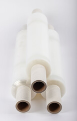 Roll of plastic stretch film with clear wrap. It stands in an isolated environment. It is used in the packaging of products. Overlapping stretch films