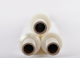 Roll of plastic stretch film with clear wrap. It stands in an isolated environment. It is used in the packaging of products. Overlapping stretch films
