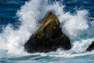 Naklejka premium wave breaking on the rocks