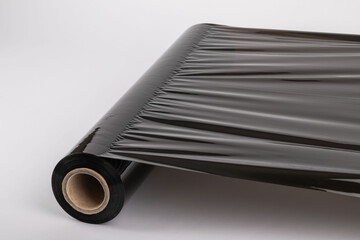 Roll of plastic cling film with black wrap. how long the roll of cling film can stretch is shown. It stands in an isolated environment. It is used in the packaging of products.