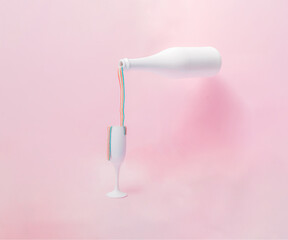 White champagne glass and bottle with colorful rainbow chewing gum how they spill on a pink pastel background.