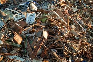 Metal scrap background. Heap of scrap metal stored for recycling. Recycling metal waste in warehouse. Grab crane unloads scrap metal in port. Unloading recycle metal waste