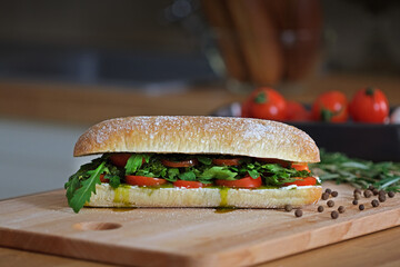 Delicious sandwich with ciabatta bread, tomatoes, mozzarella, basil, cheese, pesto sauce, fresh...