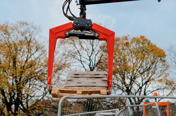 Dropside flatbed HIAB crane lorry with brick grab attachment deliver materials on construction site...