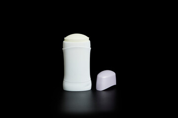 Non-branded deodorant stick. Transparent white bottle with lid set on black background and with reflection.
