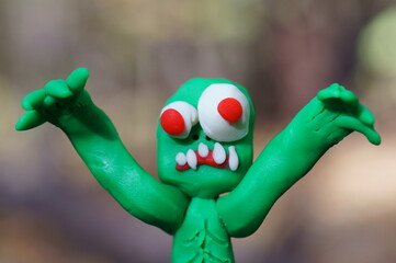 The zombie figurine is trying to scare. Funny monster made of plasticine.