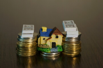 A toy house with coins and a wad of dollars on the table.