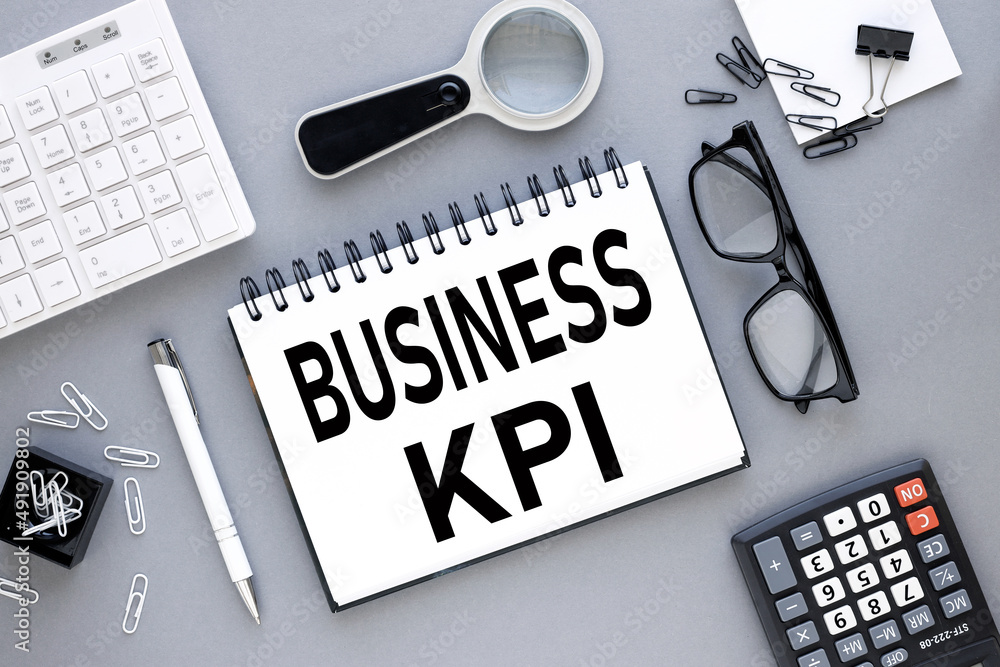 Poster business kpi - gray background, top view on notepad with text