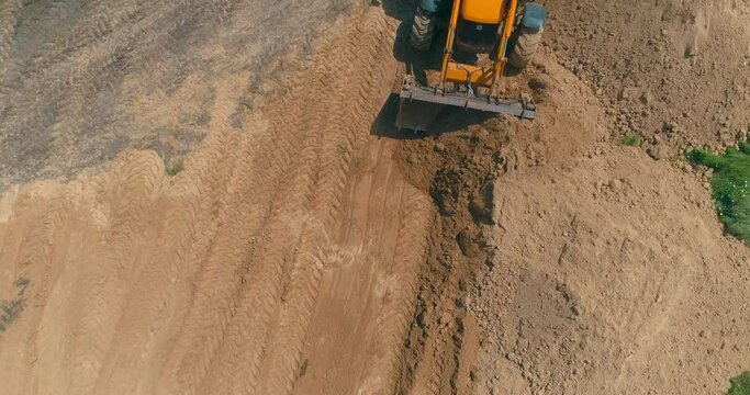 Bulldozer works at a construction site. Working process at a construction site. Bulldozer construction site aerial view