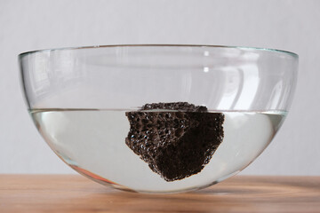 floating pumice rock in glass bowl on table