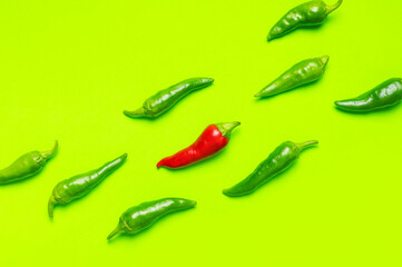 Chili peppers background. Hot red and green fresh chili peppers on green background flat lay top view. Seasoning for dish, spicy spices for cooking, cayenne pepper, food. Creative layout chili pattern