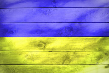 Flaga Ukrainy namalowana na drewnianych deskach. The flag of Ukraine painted on wooden boards. - obrazy, fototapety, plakaty