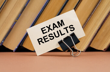 On the table against the background of books is a business card with the inscription - Exam Results