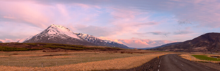 Scenic panoramic view of snow covered mountains under twilight in rural Iceland.