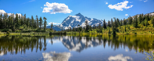 Mount Shuksan with reflections in Picture lake in Mount Baker recreation area, Evergreen trees by...