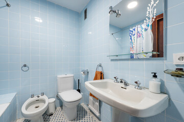 White toilet with square mirror without frames and blue tiles