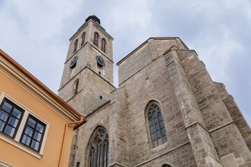 Fototapeta na wymiar Kutna Hora, Central Bohemian, Czech Republic, 5 March 2022: Gothic stone Church of St. James or Kostel sv. Jakuba with bell and clock tower, medieval architecture at old town, lancet windows