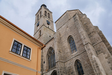 Fototapeta na wymiar Kutna Hora, Central Bohemian, Czech Republic, 5 March 2022: Gothic stone Church of St. James or Kostel sv. Jakuba with bell and clock tower, medieval architecture at old town, lancet windows