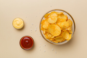 Top view chips with sause in bowl on colored background, top view with copy space