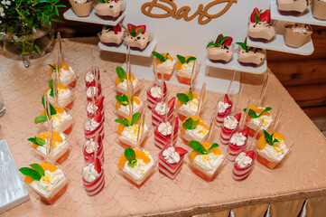 Sweet cakes in cups at a wedding buffet. Candy bar catering