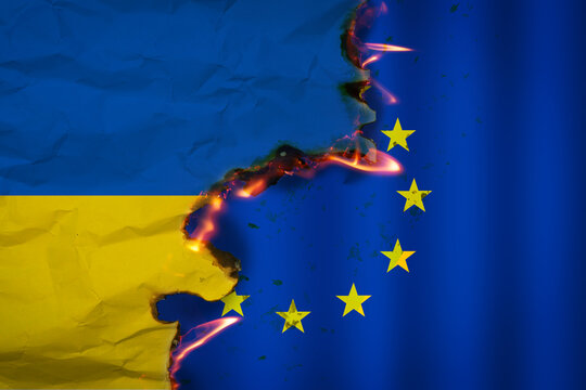 Flag of Ukraine is burned over the flag of European Union. Concept of try of entry in European Union