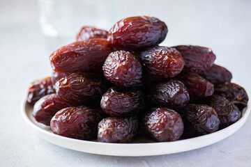 Close up of Medjoul dates in a white plate on a gray background. - 491919496