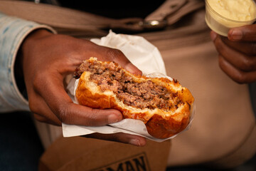 Woman holding Smash Burger with American Cheese. Delicious Smash Burger. Black woman eating a tasty smash burger