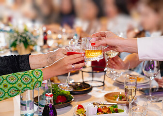 hands with glasses above the festive table