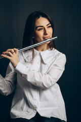 beautiful young woman playing flute. High quality photo