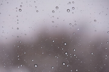 Raindrops on a window with a blurry  background 