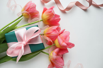 beautiful bouquet of pink tulips and a gift box with a pink bow 