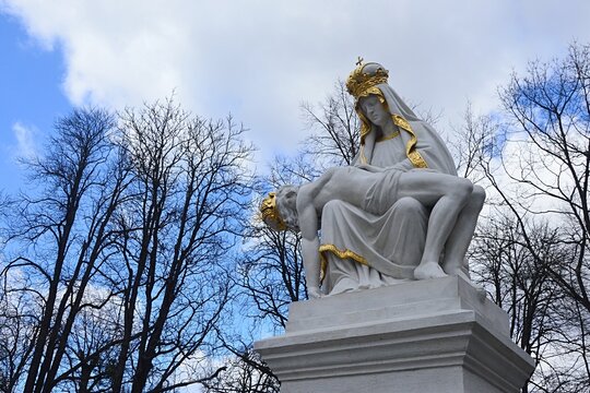 Statue of Pieta, Virgin Mary with dead body of Jesus Christ, located in front of baroque basilica in Sastin - Straze, western Slovakia, central Europe. Cloudy summer skies in background.