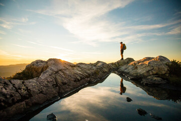 confident backpacker standing on summit ridge, Vancouver B.C.