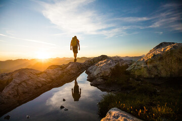 reflected view of backpacker hiking on mountain rige.