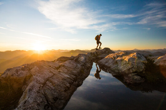 silhouetted man hiking on mountain summit, Vancouver.