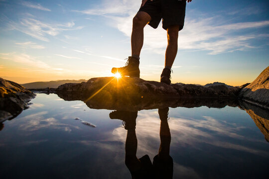 Lower half view of hiker wearing boots on mountain summit