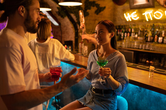 Diverse couple talking during party - Powered by Adobe