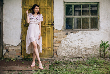 Romantic girl stand near old village house