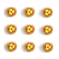 Pattern yellow pastel easter eggs in nests on a white background. Minimal creative concept of Easter.