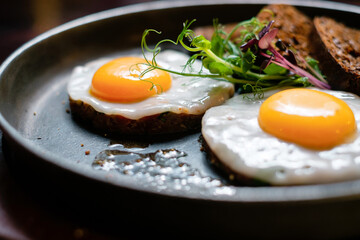 Fried eggs with bread in a pan close-up.